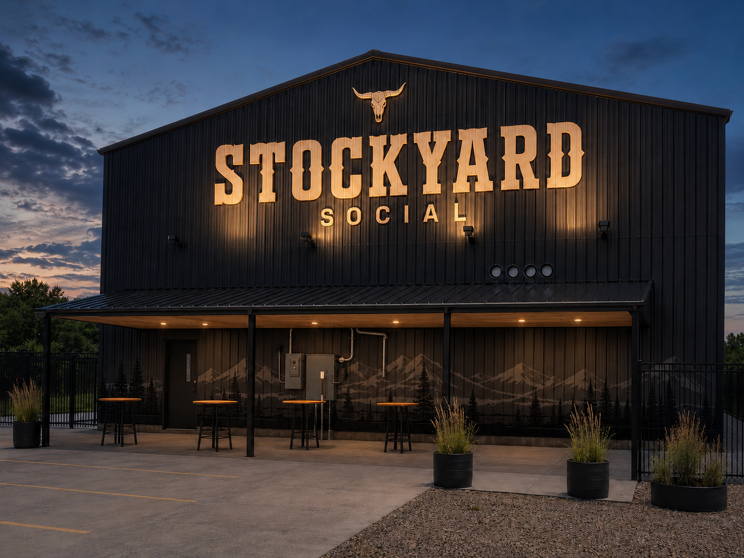 The proposed charcoal Stockyard Social stadium-facing exterior and reflective sign illuminated at night